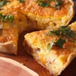 slice of ham and swiss quiche removed from pie