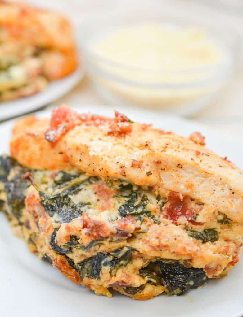 stuffed chicken breast with cheese and spinach on white plate